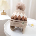 Bonnet beige à motifs écrus et marron avec pompon et cache-oreilles
